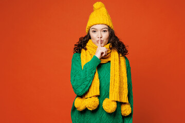 Young smiling happy woman she wear green knitted sweater yellow hat scarf say hush be quiet with...