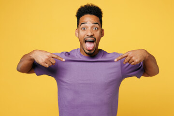 Young overjoyed exultant man of African American ethnicity he wears purple t-shirt casual clothes...