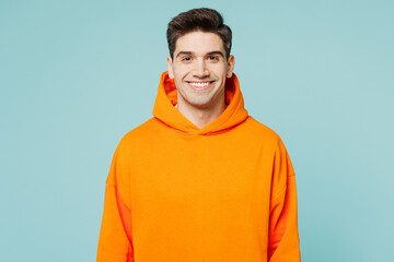 Young smiling happy cheerful satisfied fun cool man he wears orange hoody casual clothes look...