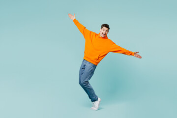 Full body young man he wear orange hoody casual clothes stand on toes leaning back with...
