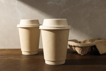 Paper cups with lids on a wooden table