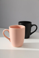 Pink and black cups on a light background