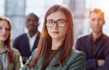 Portrait of a young serious business woman with colleagues