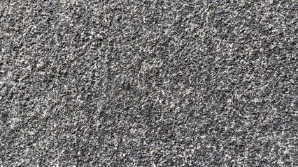 The surface of the concrete wall is covered with small gray pebbles.