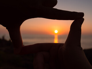 Picture of the sunset in a finger frame.