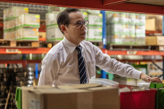 Warehouse manager process paperwork, organize goods by size, shape, category, prepare delivery date