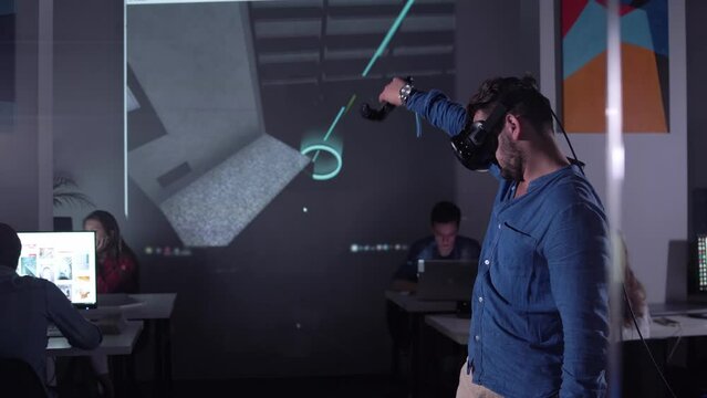 Architect Engineer Using Virtual Reality Software for His Project. Man with Headset and Controllers wearing VR headset for working design 3D architectural building model with BIM technology and