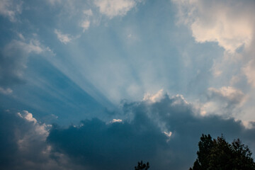 Fototapeta na wymiar Cinematic Sunset Aura: Dramatic Light Beams Through Clouds