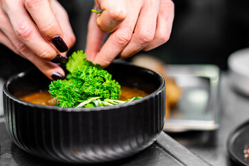 Professional chef cooking Shurpa soup with lamb meat in restaurant kitchen