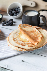 Breakfast: fresh pancakes with berries. On a wooden background. Morning