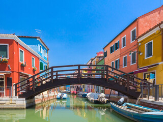 Fototapeta na wymiar Bridge over a channel in town surrounded by colourful buildings (Burano, Italy)