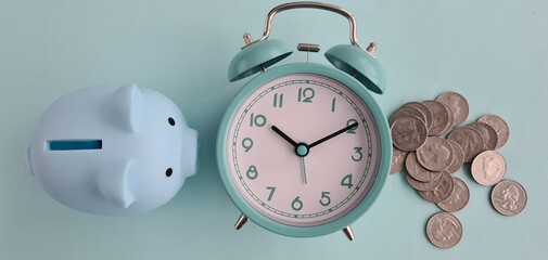 Piggy bank, alarm clock and coins. Time value of money and financial planning