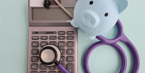 Piggy bank and calculator and health insurance