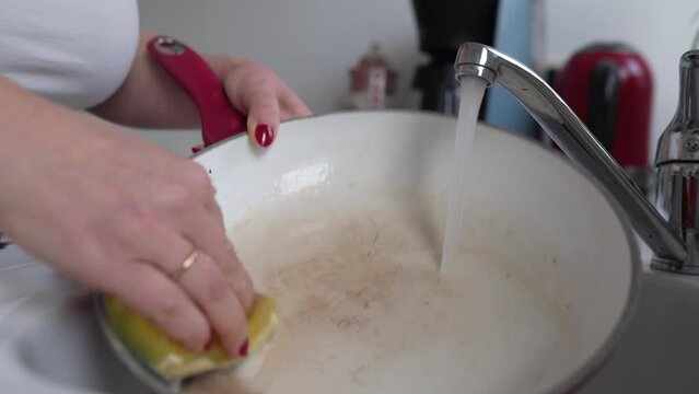Washing dirty, burnt frying pan