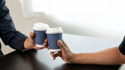 Group of businessmen drinking coffee for success in work or chatting and clinking coffee cups together. Close-up pictures