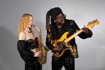 playing musical couple african man and caucasian woman on instruments