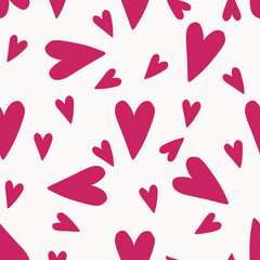 Seamless pattern of pink, raspberry hearts, large and male chaotically on a white background