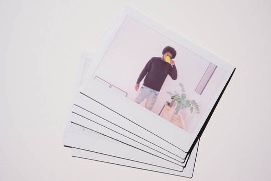 Coffee Break. A neatly stacked collection of Polaroid photos depicting a man in a black sweater taking a moment to enjoy a cup of coffee in a stylish, plant-adorned office space.
