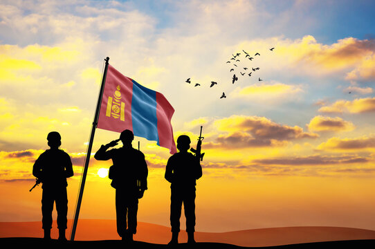 Silhouettes of soldiers with the Mongolia flag stand against the background of a sunset or sunrise. Concept of national holidays. Commemoration Day.