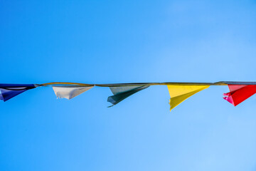 Colorful flags in the wind with sky in the background.
