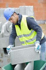 worker moving a concrete block