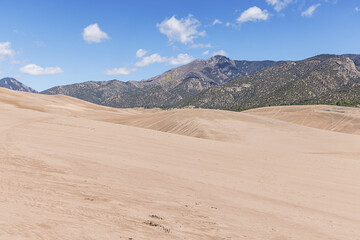 Fototapeta na wymiar Hiking in the middle of the Great Sand Dunes with the Rocky Mountains in a distance