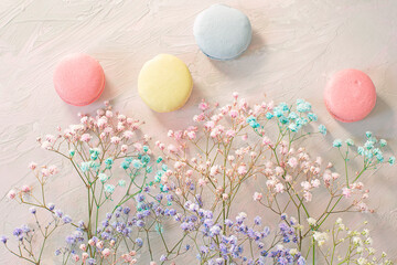 sweet colorful macaroons and cute colorful flowers on a delicate light background. Atmosphere of...