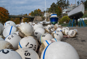 Mooring Buoys:  Floats to mark off-shore anchoring spots lie stacked in a New England boatyard on a...