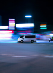 moving photograph of van in asian city with colored lights long exposure motion effect