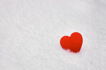 valentines day background, red glass heart on white fresh snow, love symbol