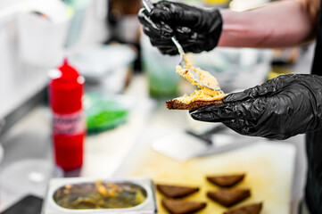 Close-up of woman chef hand spreading butter on bread in kitchen