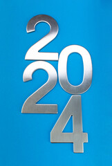 Composition with the number 2024 made of silver on a blue monochrome background