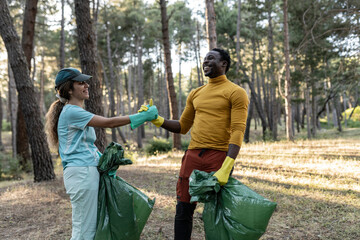 couple of volunteers successfully celebrates garbage collection in the forest