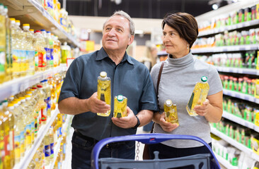 Elderly man and a woman choose extra virgin olive oil