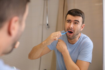 Man experimenting pain while brushing his teeth 