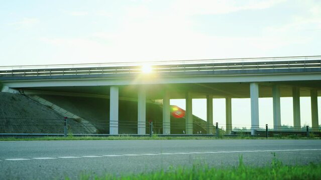 Modern lory cargo semi-trailer truck with refrigerated container is driving under overpass on highway. Flyover thruway, overbridge. Export import concept, logistic company. Freight transit, delivery
