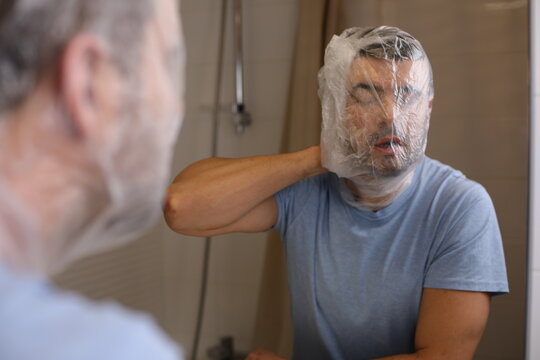 Weird man covering his head with a plastic back having difficulties to breath 
