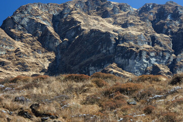 Stunning views of snow mountains, blue skies and large rocks along the track to ABC