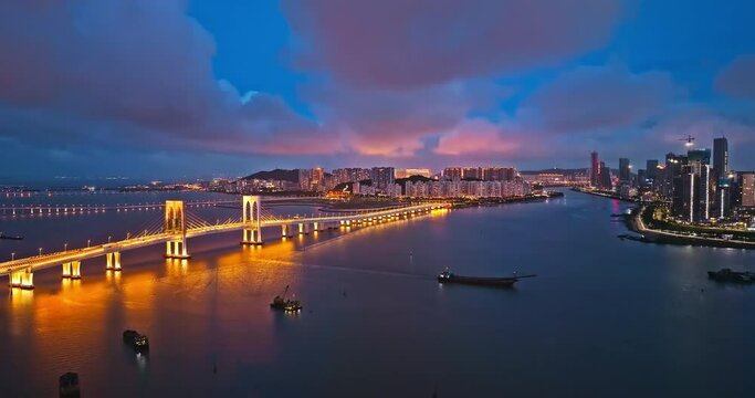 Aerial view of beautiful bridge and residential area buildings scenery at night in Macau