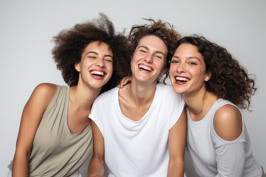Three women are laughing and posing for a picture