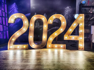 Golden digits in 2024 number with bokeh lights in the background. 2024 new year backdrop. Light and soft