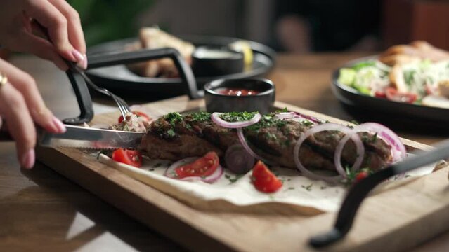 Dinner at a Turkish restaurant. A woman eating hot lula kebab served on pita bread. Grill menu concept