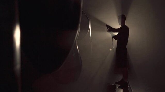 Young man using elastic bandage for his hands before put on a boxing glove for boxer training class. Sport and exercise