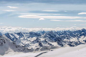 Snow-covered winter mountains of the Caucasus on a sunny day. Panoramic view from the ski slope of Elbrus, Kabardino-Balkaria, Russia - 696354550