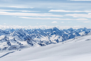 Fototapeta na wymiar Snow-covered winter mountains of the Caucasus on a sunny day. Panoramic view from the ski slope of Elbrus, Kabardino-Balkaria, Russia