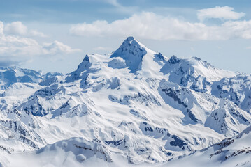 Snow-covered winter mountains of the Caucasus on a sunny day. Panoramic view from the ski slope of...