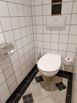  wandmontiertes Toilettenbecken mit Klopapierhalter und Reserverolle