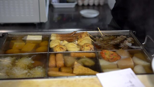 Chef preparing tofu oden hot boild daikon radish in Japanese style soup hot meal