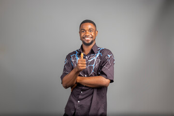 Smiling man posing with arms crossed on white background and did thumbs up