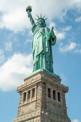 statue of liberty on blue sky and clouds background